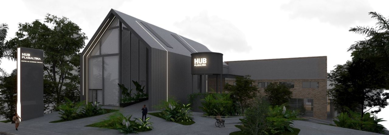 Hub Planaltina: novo volume de acesso em telha metálica escura com fachada em vidro, ao lado da edificação original em tijolos