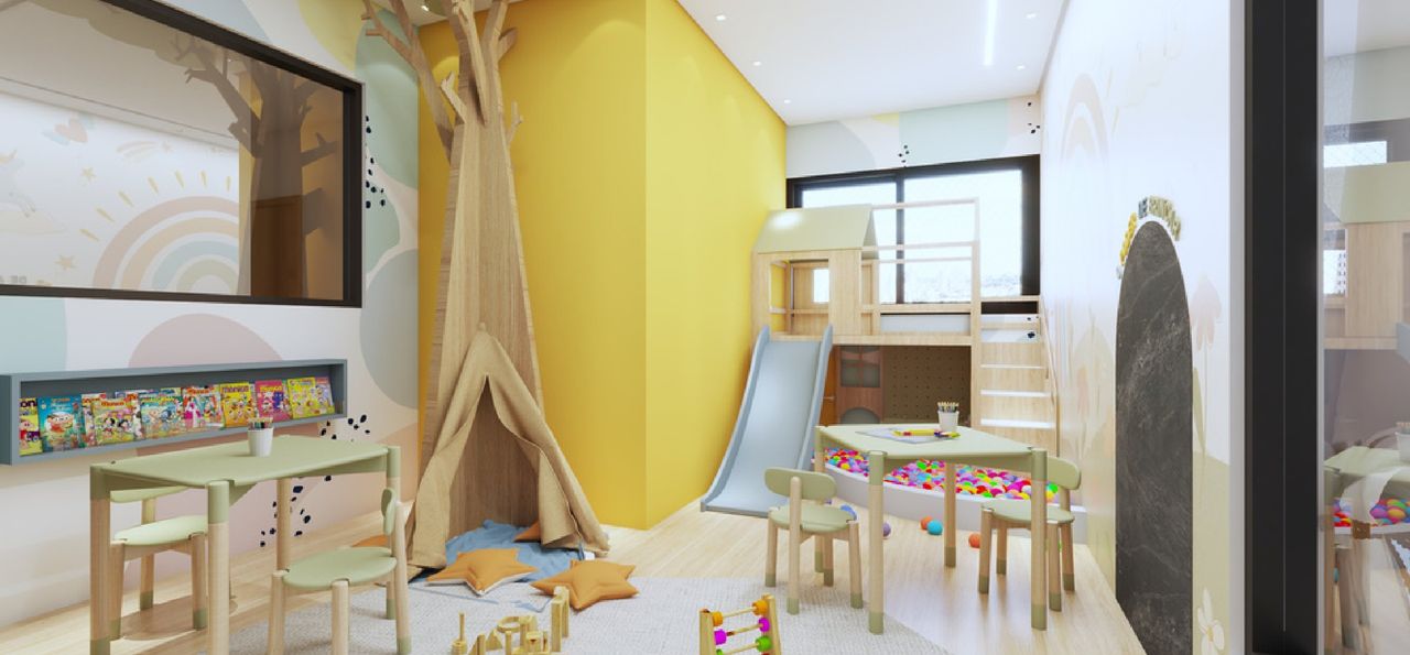 Brinquedoteca com parede amarela, árvore em madeira, cabana, escorregador e piscina de bolinhas