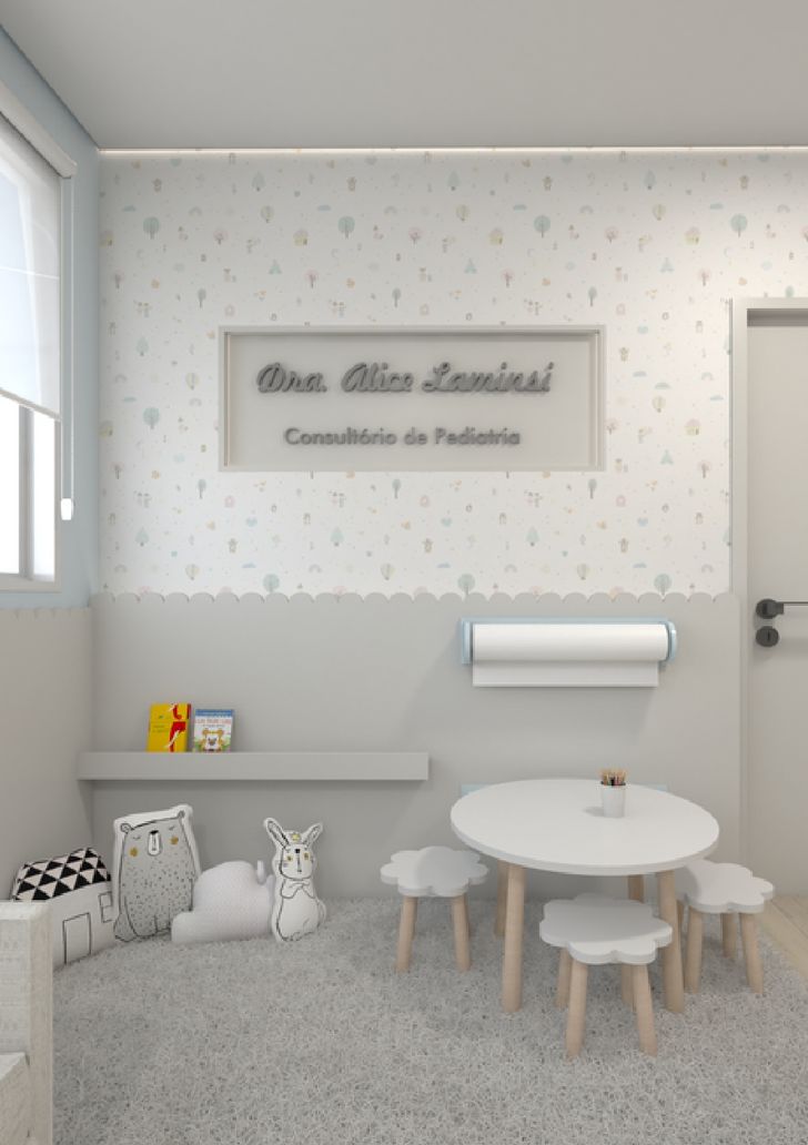 Espaço de espera infantil com papel de parede delicado, mesa redonda e bancos em formato de nuvem