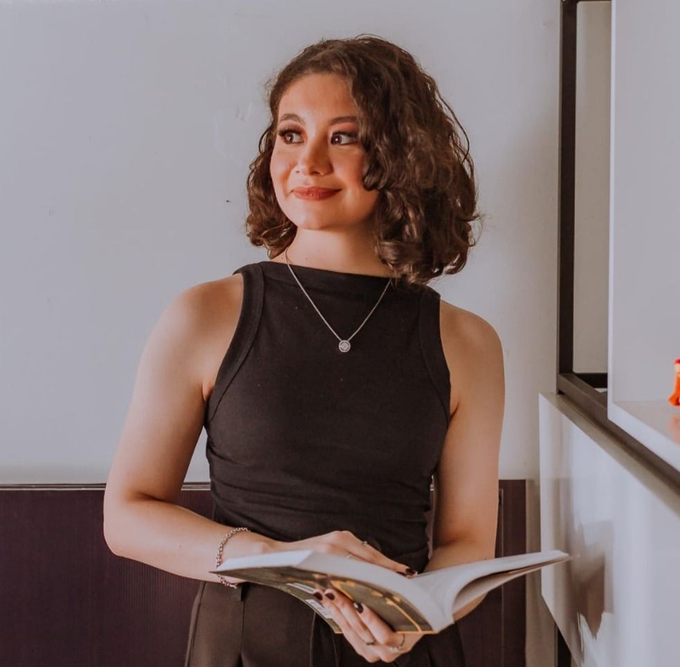 Retrato de Liriane Wagner, arquiteta e urbanista, segurando um livro aberto